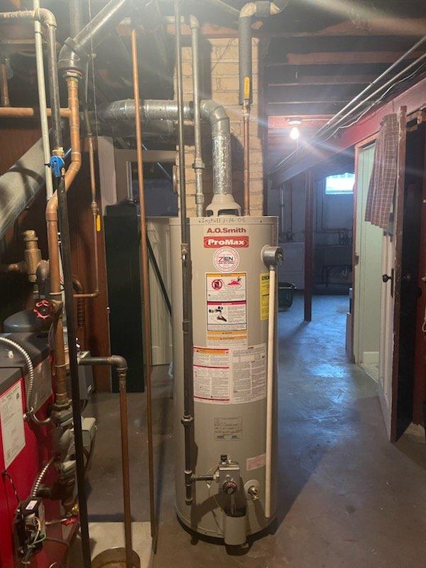 Conducted inspection of existing A.O. Smith ProMax water heater installation in basement utility area. Unit appears properly installed with appropriate ventilation piping and copper supply lines connected to household plumbing system. Verified installation meets code requirements with proper clearances and connections to existing infrastructure.