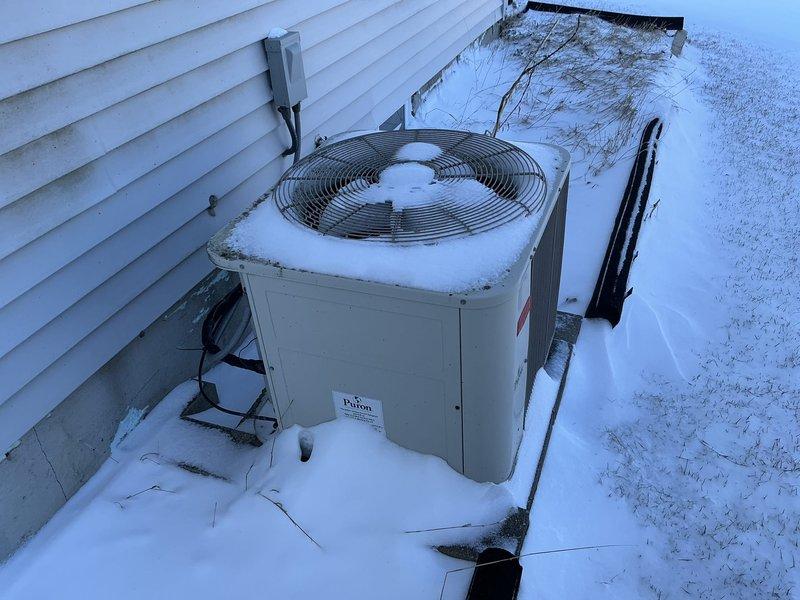 Conducted comprehensive assessment of existing HVAC system consisting of an aging Plus Ultra furnace and Payne outdoor condensing unit. System shows significant wear with snow accumulation on outdoor unit and dust buildup on indoor components, indicating replacement is recommended to improve efficiency and reliability before complete failure occurs.