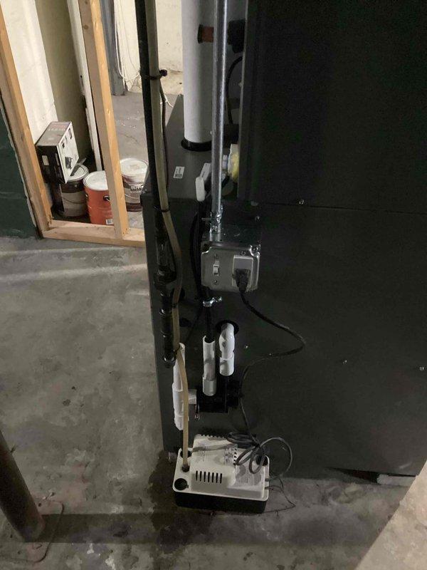 Completed installation of a complete HVAC system in basement utility area, including furnace unit with connected ductwork, electrical controls, and condensate pump. System was pressure tested with digital manometer (MA-12838A), confirming proper system pressure at 3.40 units, ensuring optimal operation of the newly installed equipment.