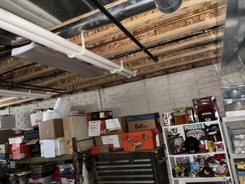 Conducted site assessment in basement area for HVAC replacement, documenting existing ductwork configuration and available installation space. Measured floor area using folding ruler to determine appropriate unit sizing requirements for the new system.