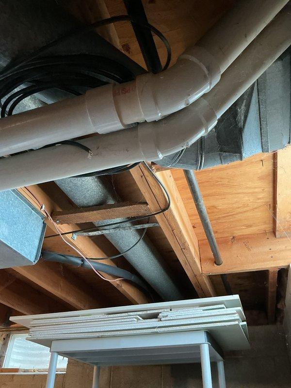 Conducted routine maintenance inspection of HVAC system. Examined interior ductwork, noting minor dust accumulation and slight oxidation around junction points. Inspected attic area to verify proper installation of nearby plumbing components and confirmed adequate clearance between PVC piping and HVAC ductwork to prevent interference with system operation.