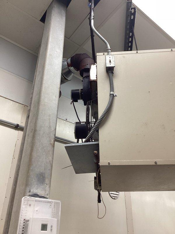 Diagnosed commercial heating system failure at ceiling-mounted HVAC unit. Inspected electrical connections, junction boxes, and control wiring along the primary support column. Repaired damaged flexible conduit connections and restored proper operation to the wall-mounted thermostat control unit.