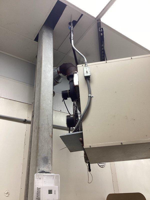 Diagnosed commercial heating system failure at ceiling-mounted HVAC unit. Inspected electrical connections, junction boxes, and control wiring along the primary support column. Repaired damaged flexible conduit connections and restored proper operation to the wall-mounted thermostat control unit.