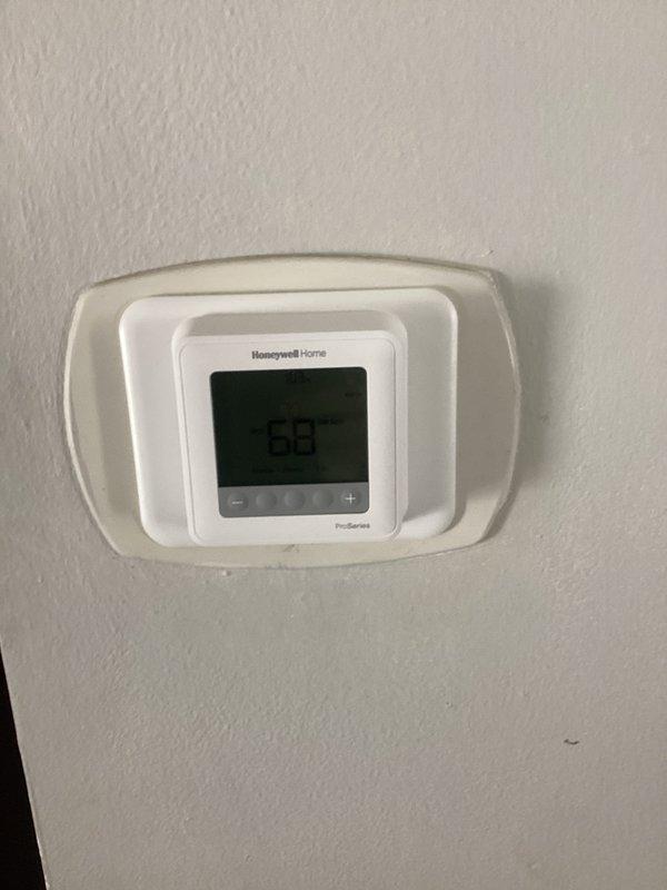 Installed a complete HVAC system including a new furnace unit with proper condensate drainage in the utility area, connected to PVC ventilation pipes. Mounted and configured a Honeywell digital thermostat displaying 68°F with functional temperature adjustment capabilities, ensuring the entire system operates efficiently.
