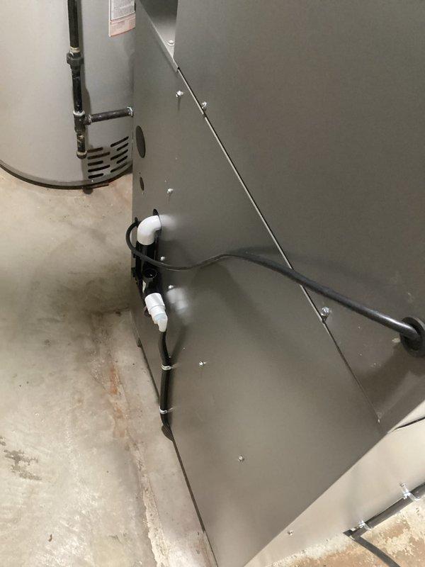 Installed a complete HVAC system including a new furnace unit with proper condensate drainage in the utility area, connected to PVC ventilation pipes. Mounted and configured a Honeywell digital thermostat displaying 68°F with functional temperature adjustment capabilities, ensuring the entire system operates efficiently.
