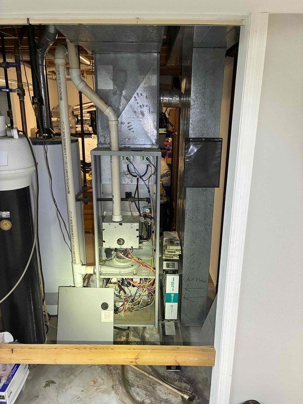 Completed installation of new furnace system in utility room, including proper venting via PVC intake/exhaust pipes and connection to existing ductwork. System was installed with accessible filter housing and all electrical components were properly wired and tested for functionality. Final inspection confirmed proper installation of all mechanical components with appropriate clearances maintained for the adjacent water heater.