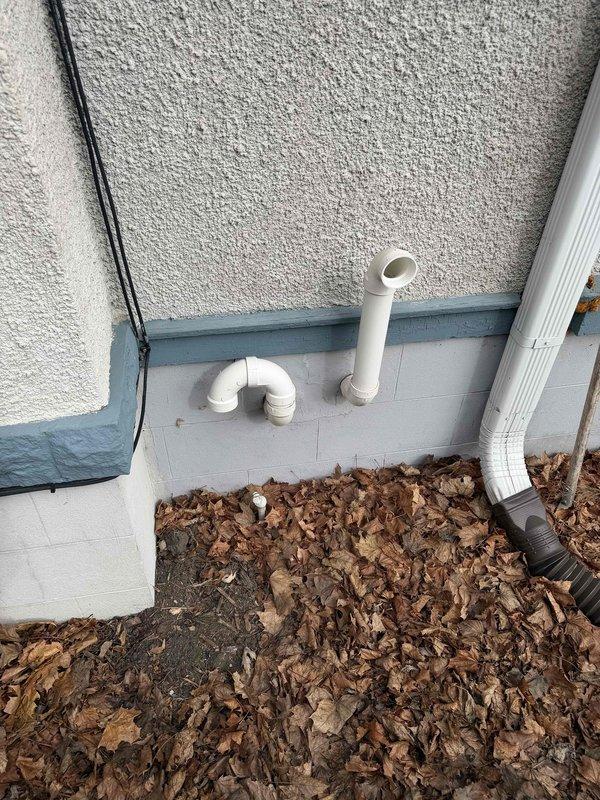 Performed inspection of existing furnace unit showing signs of wear and deterioration. Unit is currently installed on wooden shims over concrete flooring in utility area. Exterior evaluation revealed PVC exhaust pipes requiring proper sealing and alignment with building envelope. Recommended full system replacement due to age and condition of equipment.