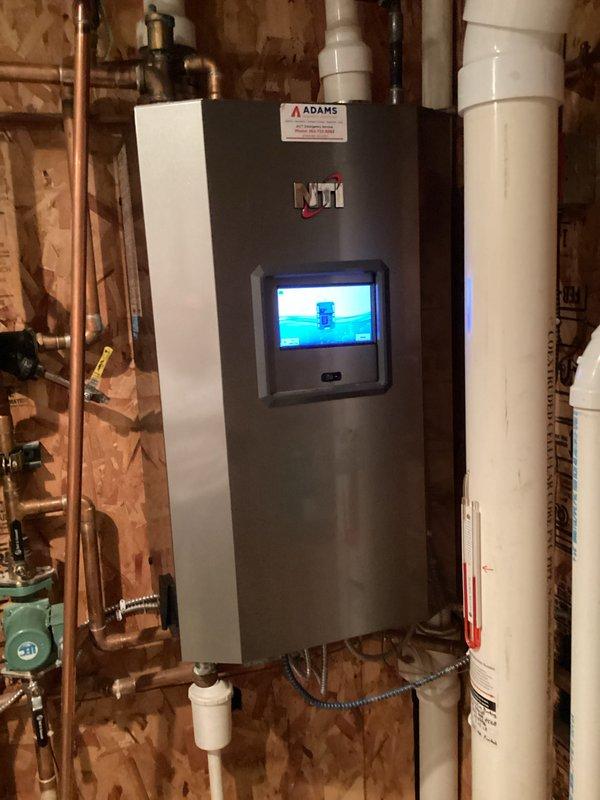 Installed new Adams boiler system with digital interface for improved climate control functionality. Connected copper supply/return lines and installed FLEX expansion tank with appropriate valves and fittings. System tested and verified operational with proper water pressure maintained throughout heating circuit.