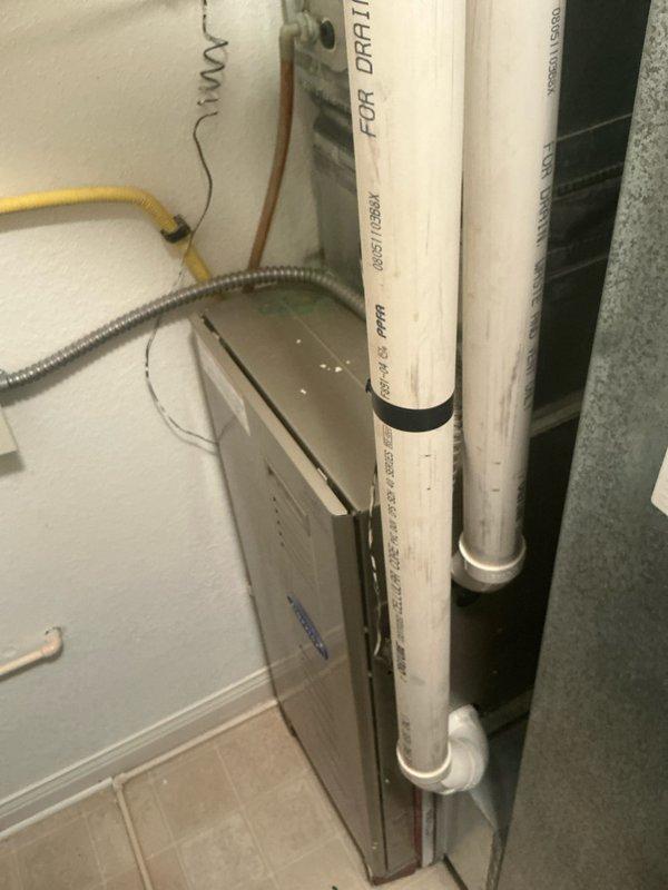 Installed new PVC drainage system for HVAC condensate line with proper labeling and secured connections. System includes vertical runs with appropriate elbows and joints, connecting to existing ductwork. All components were installed to code with necessary support brackets and insulation bands at connection points.