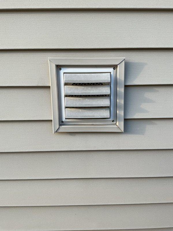 Completed installation of exterior ventilation duct with proper sealing and mounting to vinyl siding. Verified airflow functionality and inspected connection points to ensure secure attachment and weather-resistant seal around perimeter.
