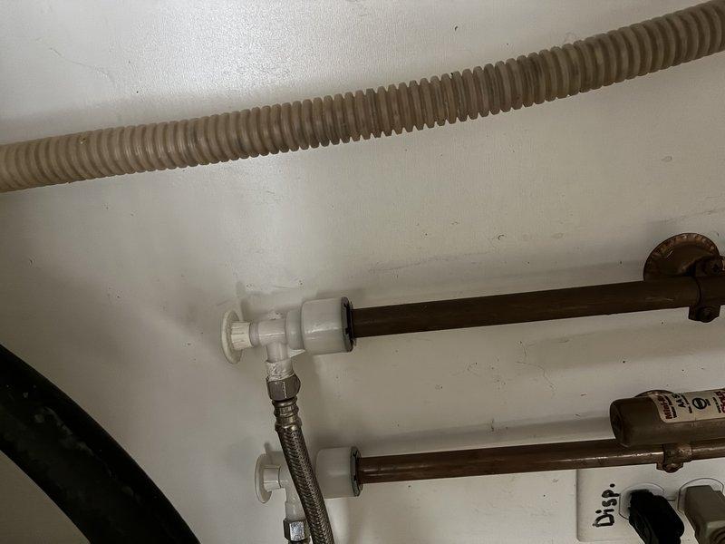 Inspected kitchen sink with dual basin and found ceramic material cracking around drain opening. Evaluated plumbing connections including copper supply lines, PVC fittings, and braided flexible hoses which were properly secured with mounting brackets. Replaced damaged faucet assembly and verified proper operation with no leaks.