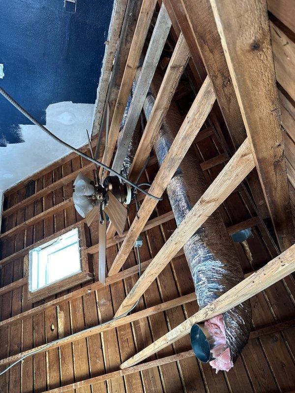 Installed new insulated metal ductwork in attic and wall cavity, properly securing and connecting the system through existing structural framing. Ensured all connections were properly sealed and insulated, with special attention to the collar joint connection visible in the exposed framework area.