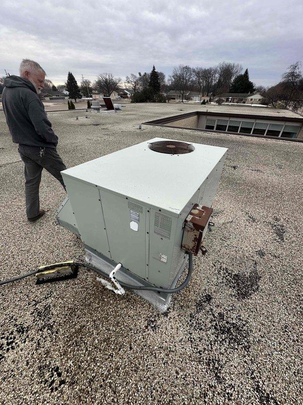 Conducted rooftop inspection of commercial mini-split system to assess condition and performance of existing units. Evaluated two rooftop HVAC units mounted on metal frames, noting current installation configuration and electrical connections to prepare comprehensive replacement estimate. Documented equipment specifications and site conditions for proposed system upgrade.