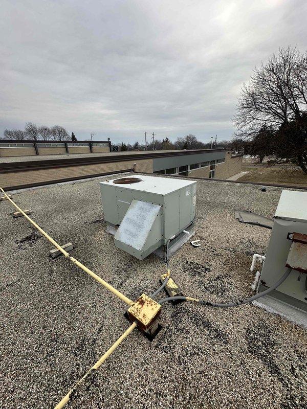 Conducted rooftop inspection of commercial mini-split system to assess condition and performance of existing units. Evaluated two rooftop HVAC units mounted on metal frames, noting current installation configuration and electrical connections to prepare comprehensive replacement estimate. Documented equipment specifications and site conditions for proposed system upgrade.