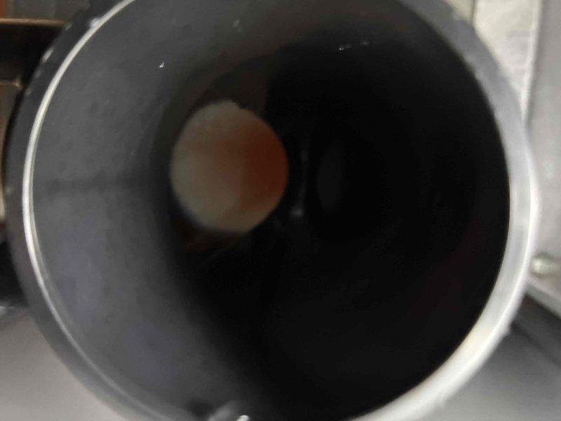 Performed inspection of HVAC system and identified moisture buildup inside cylindrical component with visible water droplets on inner walls. Visual examination revealed a partially obstructed valve/fitting and evidence of condensation issues. Further investigation of connected ductwork showed potential airflow restrictions that may be contributing to system inefficiency.