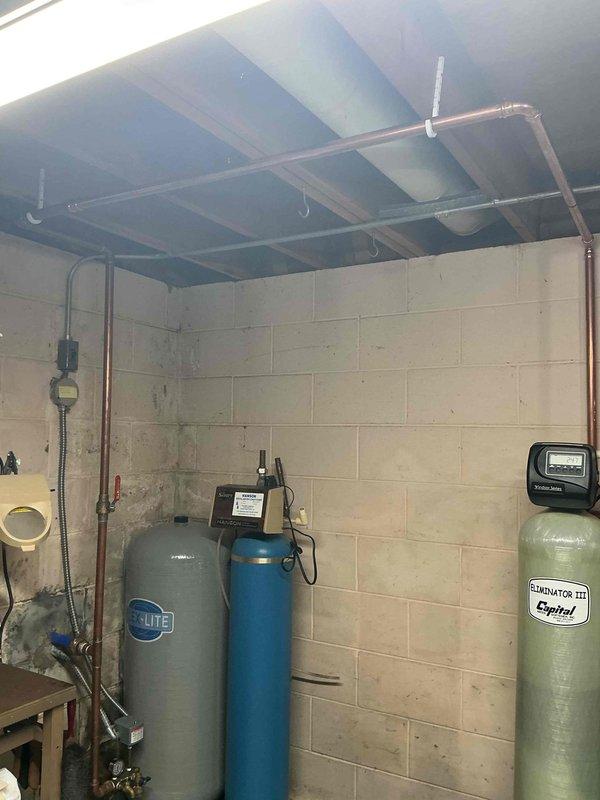 Installed complete water treatment system in basement utility area consisting of three filtration components: a CULTE gray tank, blue tank with electronic control unit, and an Eliminator III Capitol green tank. Connected system to existing copper water supply lines with appropriate valves and fittings. Completed installation of digital control panels and verified proper operation of all treatment components.