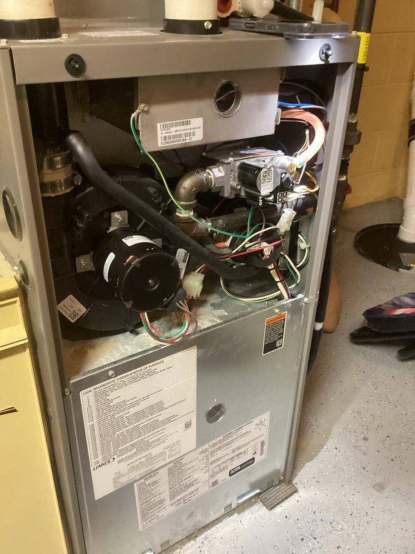 # HVAC Service Report - No Heat Call

## Service Summary
Responded to no heat call on residential gas furnace unit over 10 years old. Performed diagnostic inspection, identified failed components, and restored heating operation to customer's home.

## Work Performed

Upon arrival, conducted initial system assessment with front access panel removed to inspect internal components. Verified no heat condition and began systematic troubleshooting of the aging furnace system.

Inspected blower motor assembly located in lower section of unit, examining electrical connections and motor functionality. Tested all wire connections including green ground, red power, white common, and blue control wires throughout the system. Verified integrity of wire harness and connector blocks for proper continuity.

Examined gas valve assembly and associated copper tubing in upper section of unit for proper operation and gas flow. Inspected control board and wiring connections, noting multiple colored wire run