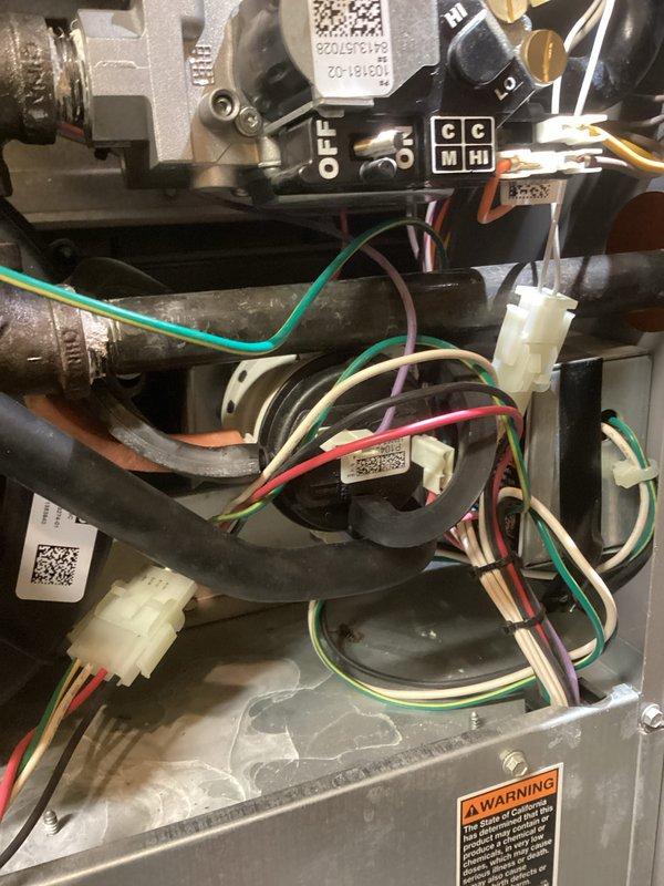 # HVAC Service Report - No Heat Call

## Service Summary
Responded to no heat call on residential gas furnace unit over 10 years old. Performed diagnostic inspection, identified failed components, and restored heating operation to customer's home.

## Work Performed

Upon arrival, conducted initial system assessment with front access panel removed to inspect internal components. Verified no heat condition and began systematic troubleshooting of the aging furnace system.

Inspected blower motor assembly located in lower section of unit, examining electrical connections and motor functionality. Tested all wire connections including green ground, red power, white common, and blue control wires throughout the system. Verified integrity of wire harness and connector blocks for proper continuity.

Examined gas valve assembly and associated copper tubing in upper section of unit for proper operation and gas flow. Inspected control board and wiring connections, noting multiple colored wire run