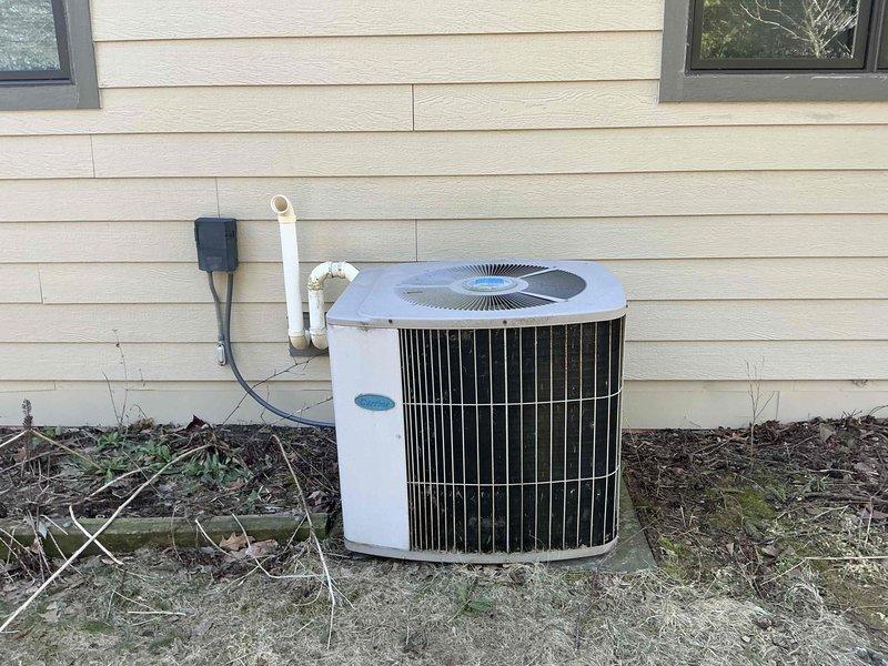 # HVAC System Estimate - Equipment Replacement

Conducted comprehensive evaluation of existing residential HVAC system for replacement estimate. Assessed current Carrier brand forced-air furnace installation located in basement mechanical room, including examination of white PVC venting configuration, refrigerant line routing, and electrical service connections. Documented existing equipment specifications and installation conditions including concrete block foundation walls, exposed structural framing, and utility room layout constraints.

Evaluated exterior Carrier condensing unit positioned against home's foundation, noting current mounting location, electrical disconnect placement, and refrigerant line penetrations through exterior wall. Assessed site conditions including ground-level installation pad, clearance requirements, and existing PVC conduit routing. Examined condition of outdoor unit including cabinet integrity, coil accessibility, and fan grille protection.

Documented m