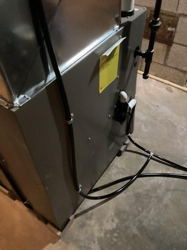 # HVAC Install - Furnace Job Summary

Completed installation of new Lennox high-efficiency furnace system in basement utility area. Unit was positioned on concrete floor against foundation wall with proper clearances maintained for service access and code compliance.

## Work Performed

Installed furnace unit with complete venting system utilizing white PVC piping routed through basement ceiling for exhaust and intake air. Venting was properly pitched and terminated according to manufacturer specifications and local building codes. All pipe joints were primed, glued, and secured with appropriate hangers and supports.

Connected refrigerant lines along right side of unit using proper mounting brackets to ensure secure routing and prevent vibration. Lines were insulated where required to prevent condensation and maintain system efficiency.

Completed all electrical connections from furnace to existing power supply, routing wiring along floor and securing to prevent damage. Verified prope