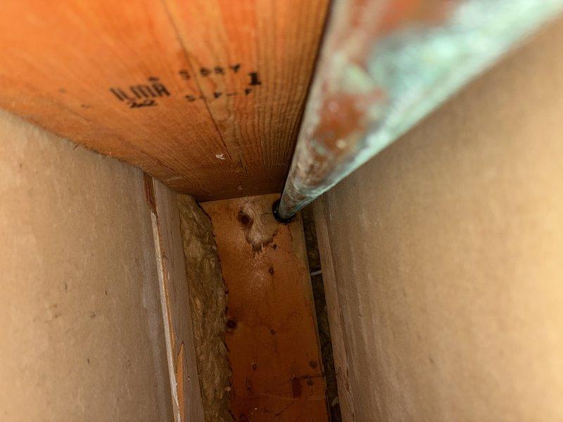 # Plumbing Site Visit Summary

Responded to service call regarding water damage and potential leak investigation. Upon arrival, conducted visual inspection of affected areas revealing significant water staining and discoloration on concrete flooring near wall junction, indicating recent or ongoing moisture intrusion. Accessed crawlspace to trace source of water damage and inspected plumbing infrastructure within floor joist cavity. Identified compromised supply line with visible signs of deterioration and moisture accumulation on pipe insulation. Documented conditions with photographic evidence showing extent of floor damage and location of affected plumbing components within structural cavity. Recommended immediate pipe replacement and remediation of water-damaged flooring to prevent further structural deterioration and potential mold growth.
