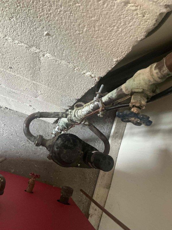 # HVAC Estimate - Replacement Summary

Conducted comprehensive assessment of existing hydronic heating system showing significant deterioration and corrosion throughout circulation pump assembly and associated piping infrastructure. Documentation revealed extensive mineral deposits, oxidation on copper and metal piping connections, and aging pump unit with compromised fittings requiring complete system replacement to ensure reliable heating operation and prevent potential failure.

# Detailed Assessment

The inspection identified a ceiling-mounted circulation pump assembly with multiple copper and metal pipe connections exhibiting advanced corrosion and mineral buildup. The pump unit displayed considerable weathering with darkened housing and deteriorated surface finish. Critical observations included white crusty deposits indicating long-term water seepage or condensation issues, oxidation on pipe joints and fittings, and visible wear on metal surfaces throughout the assembly.

The pi