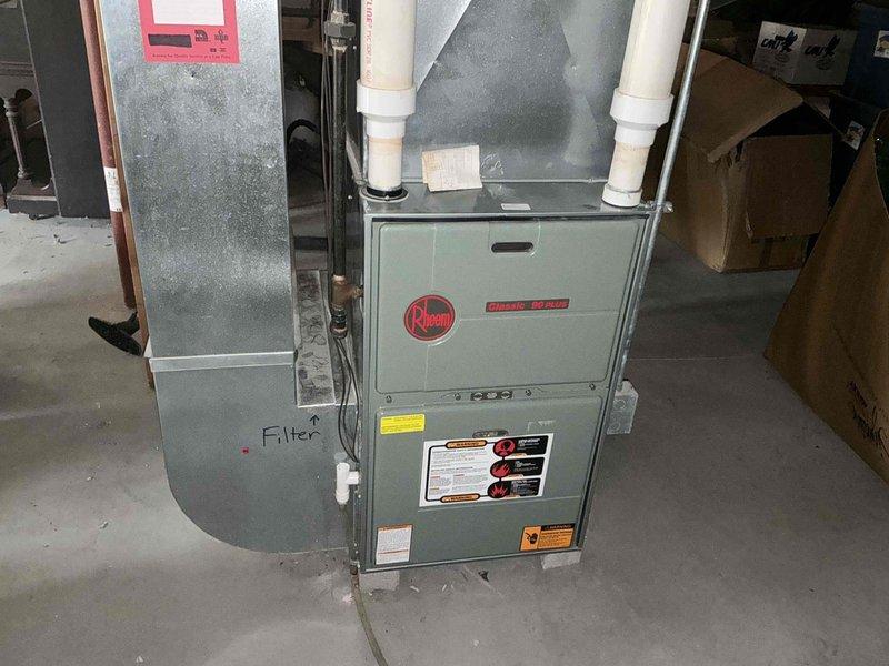 Completed comprehensive HVAC system evaluation for equipment replacement estimate at residential property. Assessment included existing Rheem furnace installation in basement utility area with connected air handler and filter housing, plus exterior air conditioning unit positioned in side yard corner showing signs of weathering and requiring attention to surrounding clearance area. Documented current system configuration, equipment specifications, and installation conditions to provide accurate replacement recommendations for complete heating and cooling system upgrade.