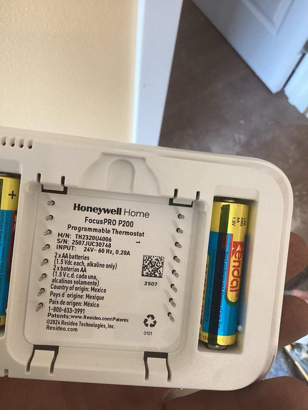 Completed installation warranty service for Honeywell Home FocusPRO P200 programmable thermostat (Model TH2320U1006). Verified proper mounting on wall, confirmed battery installation with alkaline AA batteries, and validated thermostat display functionality showing accurate temperature reading of 63 degrees. Unit tested and operating within manufacturer specifications.