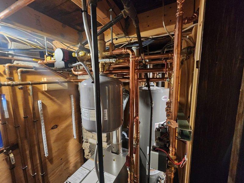 # HVAC Install - Boiler

Completed comprehensive boiler installation in mechanical room including full integration with existing plumbing infrastructure. Installed new boiler system with extensive copper piping network featuring multiple diameter runs for supply and return lines, ensuring proper water circulation throughout the heating system. Configured all necessary connections to water heater, expansion tank, and distribution manifolds with professional soldered joints and appropriate isolation valves for future serviceability.