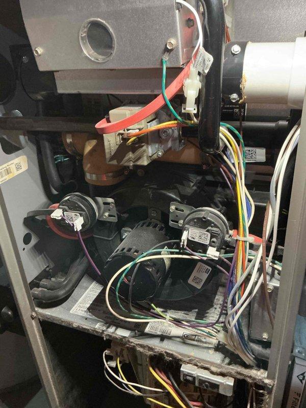 # HVAC Service Report - No Heat Call

Responded to no heat call on Lennox Elite furnace system. Upon arrival, conducted visual inspection of unit and opened access panel to examine internal components. Found unit in non-operational state with no active heating cycle.

Performed thorough diagnostic inspection of electrical and mechanical systems within furnace compartment. Examined control board, wiring connections, capacitors, and associated components for signs of failure or malfunction. Noted significant discoloration and residue accumulation on lower metal shelf inside unit, indicating possible previous moisture intrusion or operational issues.

Inspected all wire bundles and electrical connections throughout the system, including multi-colored wiring harnesses secured with zip ties. Verified integrity of connections between control systems and operational components. Checked capacitors, motor assemblies, and related electrical devices for proper function and secure mounting.

Asses