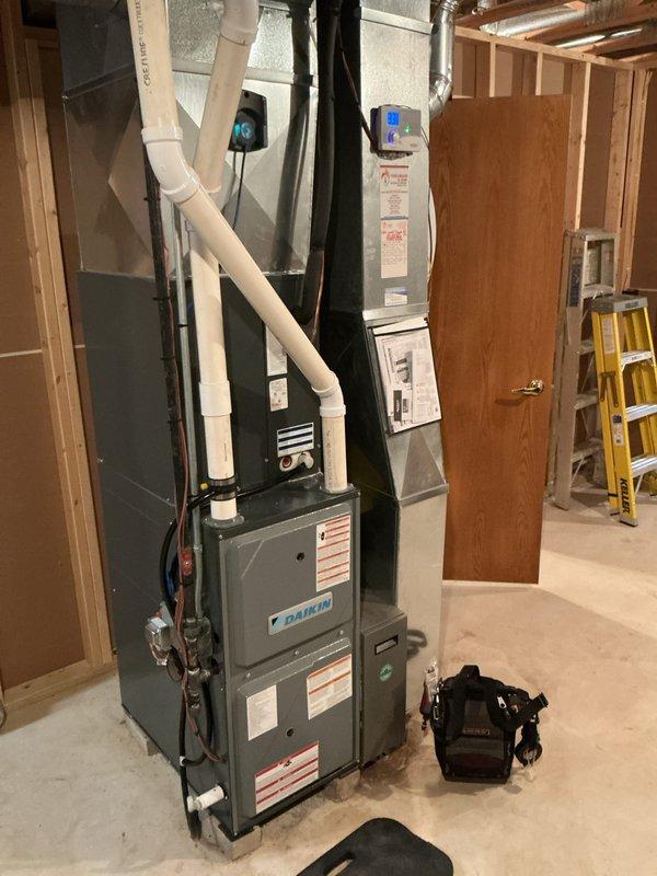 Completed preventative maintenance tune-up on Daikin furnace system in residential basement installation. Performed comprehensive inspection of unit, verified proper operation of all safety controls, checked and cleaned burner assembly, inspected heat exchanger for cracks or deterioration, tested ignition system functionality, and confirmed adequate combustion air supply and proper venting through white PVC piping. Verified all electrical connections were secure, measured temperature rise across heat exchanger within manufacturer specifications, and ensured ductwork connections were properly sealed to maximize system efficiency.