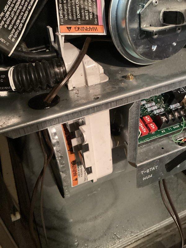 # Furnace Inspection and System Assessment

Performed comprehensive inspection of residential gas furnace system. Removed front access panel to evaluate internal components and operational status. Inspected burner assembly and confirmed proper flame characteristics with visible blue flame pattern indicating complete combustion. Examined gas valve assembly and verified all electrical connections including red, white, green, and black wire terminations were secure and properly seated.

Assessed blower motor assembly housing and internal cabinet components for proper operation and mechanical integrity. Inspected control boards and electronic components throughout the unit, including circuit boards with associated wiring harnesses. Verified all safety labels and specification tags remained legible and properly affixed to respective components.

Evaluated thermostat and humidifier control wiring marked on interior panel. Noted normal dust accumulation consistent with equipment in regular se