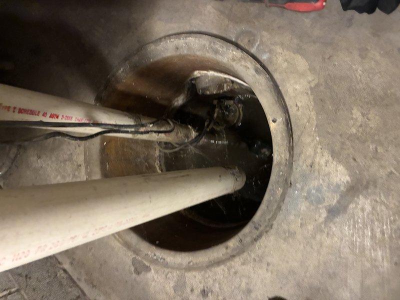 Performed sump pump inspection and maintenance in basement utility area. Examined pump mechanism installed in concrete floor pit with PVC discharge piping system, verified proper operation of motor unit and mechanical components, and assessed drainage configuration. Confirmed piping connections, checked for proper water discharge flow through the vertical PVC system, and ensured all electrical connections were secure and functioning correctly.