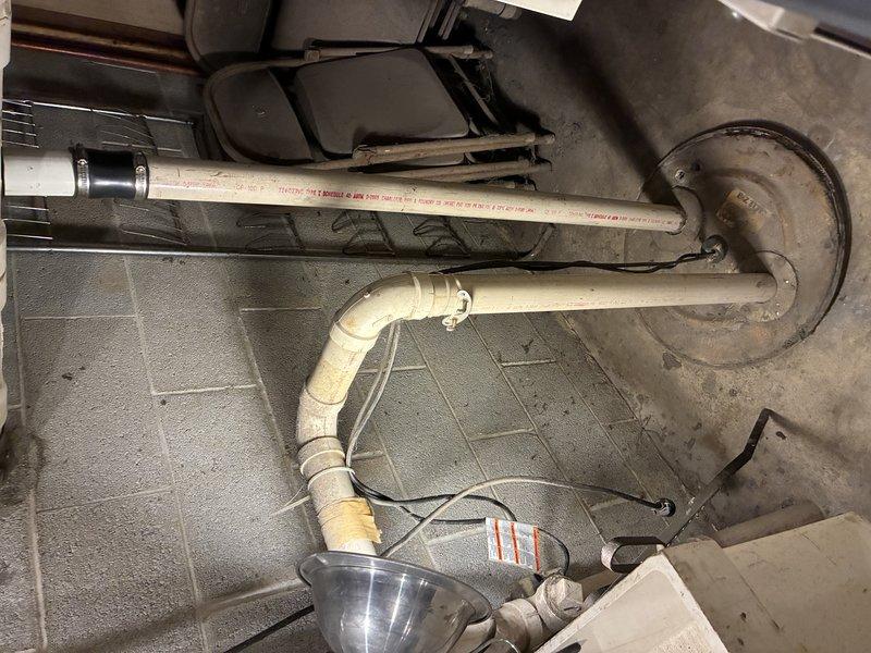 Performed sump pump inspection and maintenance in basement utility area. Examined pump mechanism installed in concrete floor pit with PVC discharge piping system, verified proper operation of motor unit and mechanical components, and assessed drainage configuration. Confirmed piping connections, checked for proper water discharge flow through the vertical PVC system, and ensured all electrical connections were secure and functioning correctly.