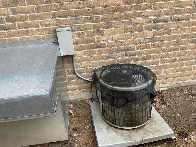 Completed full HVAC system replacement including removal of existing Armstrong Air furnace from interior utility closet and outdoor condensing unit. Installed new high-efficiency furnace in existing closet location with proper venting through PVC exhaust and intake piping, and replaced outdoor condenser unit on concrete pad with new equipment including electrical disconnect box and refrigerant line connections to brick-mounted service panel.