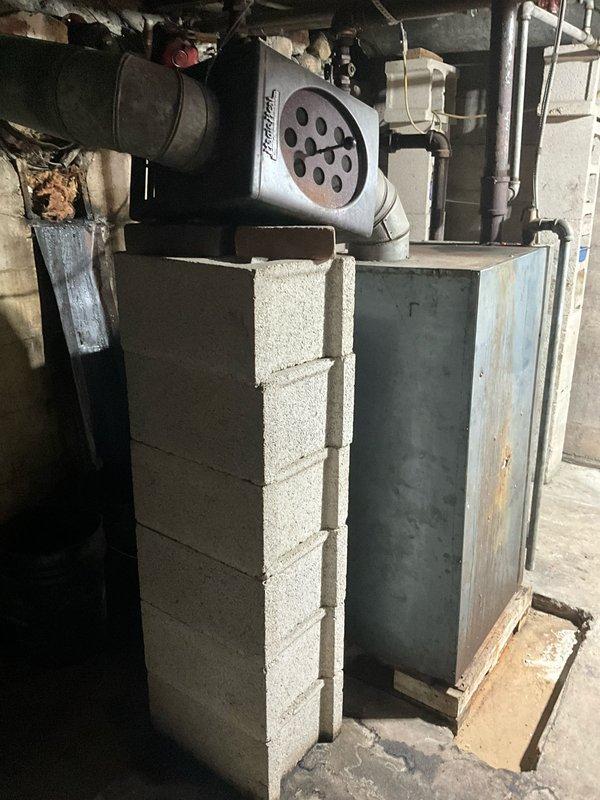 Completed comprehensive HVAC estimate for complete heating system replacement in residential basement. Existing equipment consists of an aging furnace with significant deterioration, including extensive rust on the blue-painted cabinet exterior, corroded panels, and paint failure indicating prolonged moisture exposure and end-of-service-life condition. The current installation includes a deteriorated boiler unit with associated pumping equipment, various aging piping configurations including metal and PVC connections, and outdated ductwork systems. Assessed all mechanical components, electrical connections, venting arrangements, and spatial requirements for new equipment installation. Documented existing system layout including cinder block enclosure, ceiling-mounted ductwork, exposed joists, and concrete floor conditions to determine optimal replacement configuration and any necessary structural modifications for modern high-efficiency equipment installation.