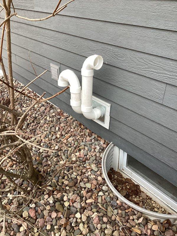 Installed new PVC condensate drain line assembly on building exterior, routing drainage away from foundation with properly configured elbows and fittings. Secured drain termination points through wall-mounted junction plate and verified proper pitch for gravity drainage. System tested and operational with no leaks detected.