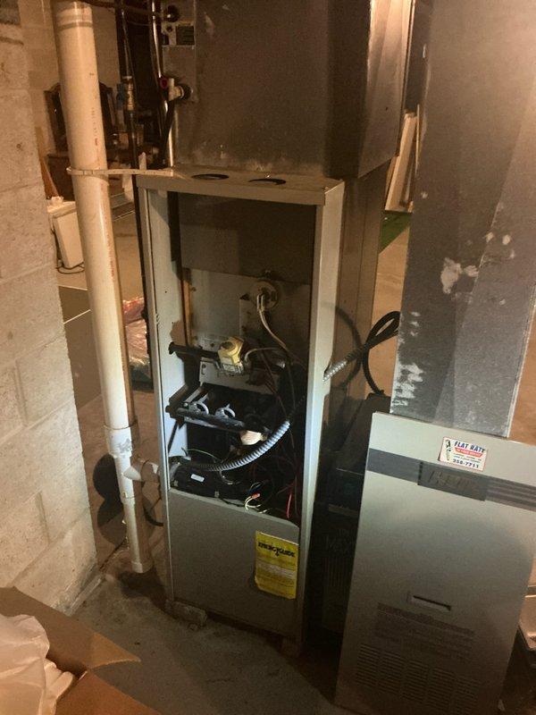 Conducted comprehensive assessment of existing HVAC system in basement utility area for complete replacement estimate. Evaluated current furnace unit with exposed internal components, including gas valve assembly, electrical connections, and mechanical systems, documenting equipment condition and accessibility for future installation. Photographed existing ductwork configuration, including vertical metal chase running floor to ceiling, and assessed surrounding workspace conditions to determine material requirements and installation logistics for proposed system replacement.