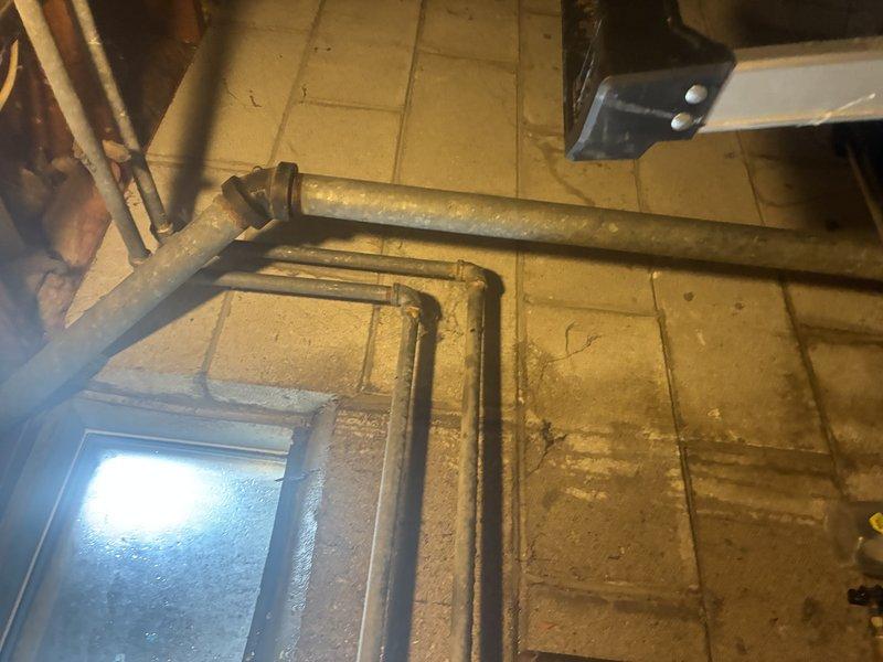 Responded to emergency call for broken pipe in basement mechanical space. Upon arrival, located compromised copper water line running along ceiling joists near HVAC ductwork system. Isolated water supply to affected section and drained remaining water from damaged pipe segment. Removed corroded section of pipe showing significant oxidation and age-related deterioration. Cut and removed approximately 18 inches of compromised copper piping, deburred pipe ends, and cleaned connection points. Installed new copper pipe section using proper sweat-soldering techniques with lead-free solder to ensure code-compliant connections. Tested all joints for leaks under full pressure, confirmed system integrity, and restored water supply to building. Inspected surrounding piping infrastructure for additional signs of corrosion or potential failure points given the age of the existing plumbing system.