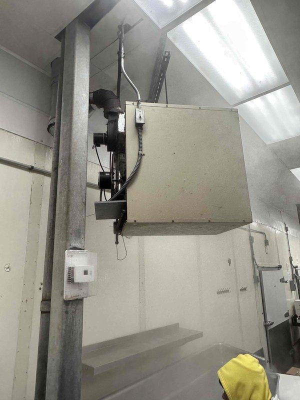 Completed commercial HVAC equipment replacement estimate for a food processing facility, assessing existing rooftop unit mounted in mechanical room with wall-mounted controls and evaluating requirements for new equipment installation to maintain proper temperature control and air quality standards in the production area. Documented current system configuration including mounting hardware, electrical connections, ductwork connections, and thermostat placement to ensure accurate replacement specifications for the climate-controlled food preparation environment with multiple work stations.