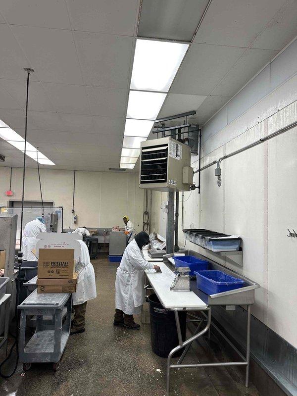 Completed commercial HVAC equipment replacement estimate for a food processing facility, assessing existing rooftop unit mounted in mechanical room with wall-mounted controls and evaluating requirements for new equipment installation to maintain proper temperature control and air quality standards in the production area. Documented current system configuration including mounting hardware, electrical connections, ductwork connections, and thermostat placement to ensure accurate replacement specifications for the climate-controlled food preparation environment with multiple work stations.