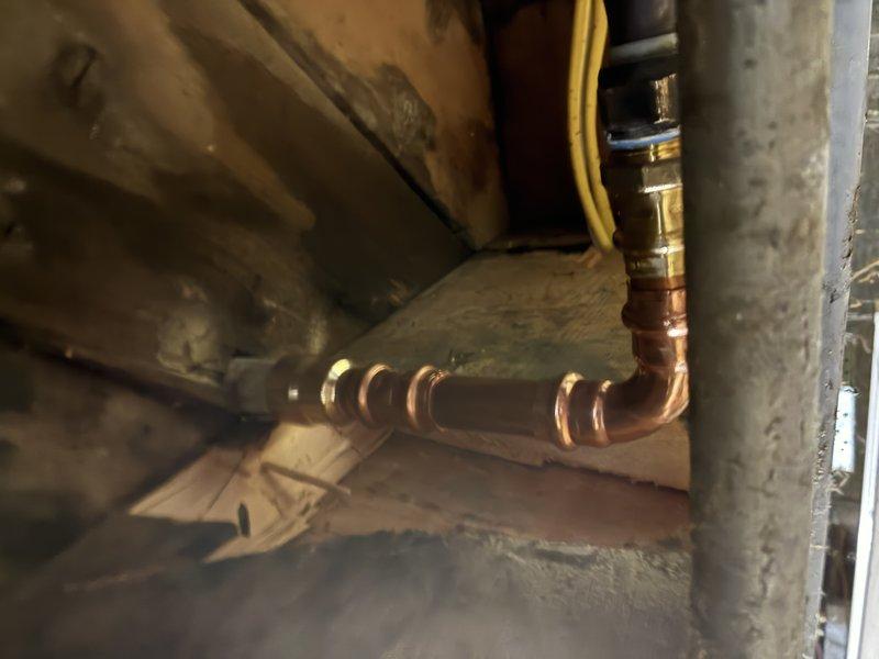 Responded to a plumbing service call for shower/tub issues and performed an inspection of the water supply system. Upon investigation, discovered severely corroded galvanized piping with extensive mineral buildup and scale accumulation that had significantly restricted water flow and reduced the internal diameter of the pipes. Replaced the deteriorated pipe section with new copper piping, installing compression fittings to ensure proper connections. The old pipe exhibited heavy corrosion throughout, with thick crusty deposits coating the interior walls, which was causing reduced water pressure and flow issues to the shower/tub fixtures. Completed the pipe replacement in the basement/crawl space area, securing all new copper lines properly along the existing floor joists to restore full water flow capacity to the bathroom fixtures.