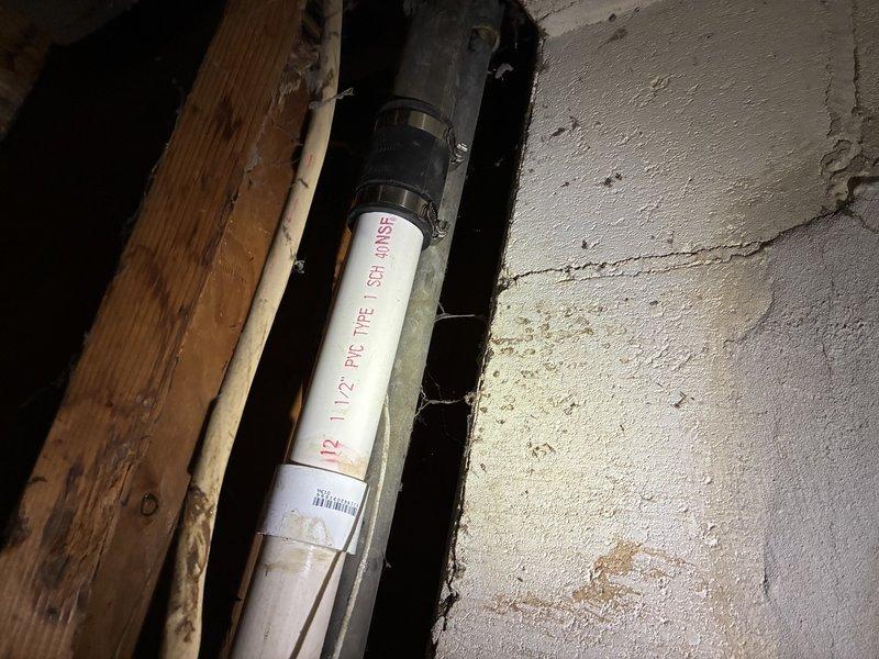 Responded to emergency call for burst pipe in interior wall cavity. Upon inspection, discovered compromised 1-1/2" PVC Schedule 40 drain line with failed connections and significant water damage to surrounding structural components. Removed damaged sections of pipe and corroded metal reinforcement brackets that had deteriorated due to prolonged moisture exposure. Installed new PVC piping with proper rubber coupling clamps to ensure secure, leak-free connections between pipe sections. Verified all joints were properly seated and tightened to manufacturer specifications. Tested repaired line for leaks and confirmed proper drainage flow. Addressed water damage concerns and documented condition of surrounding wooden framing members for potential follow-up structural assessment.