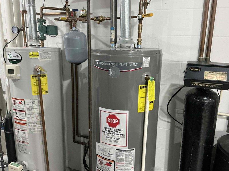 Completed comprehensive HVAC estimate for complete water heating system replacement in residential mechanical room. Evaluated existing equipment including two A.O. Smith water heaters, expansion tank, and Hanson water treatment system, all interconnected with copper piping and brass fixtures. Assessed current installation configuration, equipment condition, and provided recommendations for modernized replacement units with improved energy efficiency ratings and updated safety features to meet current code requirements.