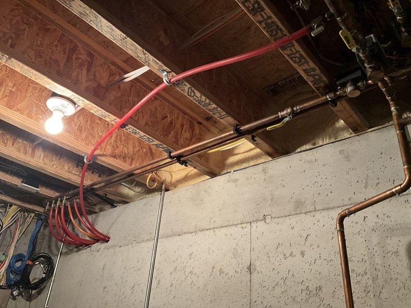 Completed comprehensive HVAC system assessment in unfinished basement utility space to provide equipment replacement estimate. Documented existing mechanical infrastructure including ductwork, copper refrigerant lines, PEX plumbing, electrical conduits, and ventilation systems routed through exposed ceiling joists. Evaluated current system configuration and accessibility for future equipment replacement installation.