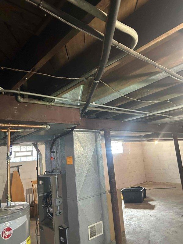 Conducted comprehensive HVAC system evaluation for indoor air quality estimate at residential property. Assessment included inspection of basement mechanical equipment featuring Rheem water heater and furnace unit with existing ductwork configuration, as well as exterior condensing unit with refrigerant line set and electrical disconnect. Documented current system layout and infrastructure to provide recommendations for IAQ enhancement solutions.