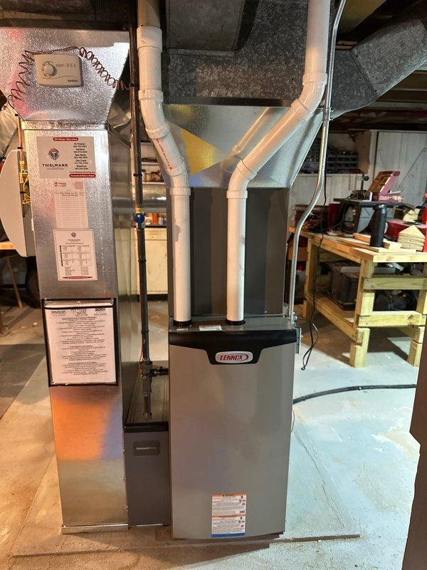 Completed full HVAC system installation in residential basement, including new Patriot high-efficiency furnace and Lennox air handler with Thermann branded components. Installed copper refrigerant line sets with proper insulation, white PVC condensate drainage and venting system, and gray metal supply/return ductwork with plenum transitions. Mounted all equipment on protective base pads over concrete flooring with proper clearances for code compliance and future maintenance access. Ran electrical connections, secured all piping and ductwork, verified system startup, and tested all components for proper operation.