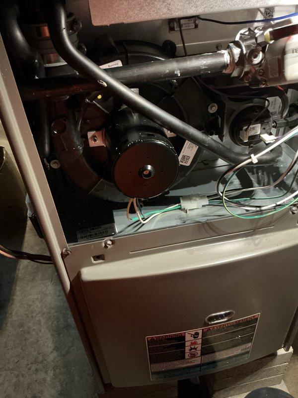 # Warranty Service Completed

Responded to warranty service call for HVAC furnace unit. Upon arrival, removed access panel to perform comprehensive system inspection. Examined all internal components including blower motor assembly, inducer motor, gas valve connections, and electrical wiring harnesses. Inspected black condensate drainage pipes for proper flow and verified no blockages present. Checked all wire connections including green ground wires and multi-colored control wiring for secure terminations. Verified proper operation of white control board with associated switching mechanisms and confirmed all safety circuits functioning correctly. Inspected metallic cylindrical motor assemblies and associated mounting hardware for secure installation. All components found operating within manufacturer specifications. Unit tested and returned to normal operation.