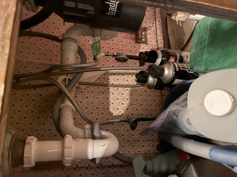 Responded to clogged drain call and performed diagnostic inspection of under-sink plumbing system. Upon investigation, discovered significant black buildup and debris accumulation inside brass T-fitting and connecting pipes, restricting water flow and causing drainage issues. Disassembled drain assembly including PVC connections and flexible supply lines. Thoroughly cleaned brass fitting interior, removing mineral deposits, corrosion, and accumulated sediment. Inspected all plumbing components for additional blockages or damage. Reassembled drain system with proper threading and sealing. Tested water flow and drainage to confirm full restoration of proper function. System now operating at normal capacity with no restrictions.