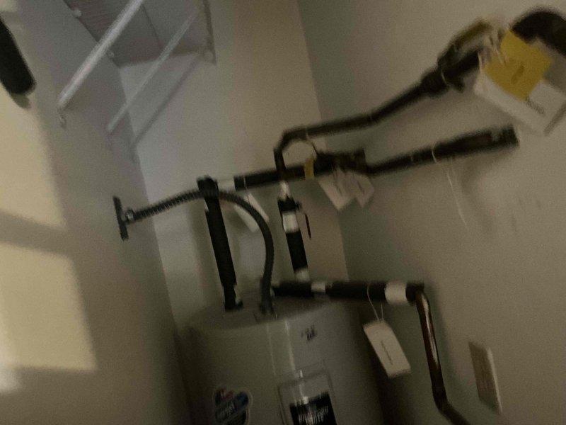 # Water Heater Inspection and Assessment

Conducted comprehensive inspection of Bradford White residential water heater installation. Evaluated all plumbing connections, including copper supply lines showing age-related oxidation and patina development. Assessed black pipe fittings and flexible gas line connections at top of unit for proper installation and code compliance. Verified earthquake strapping and wall-mounted safety restraints are properly secured to ensure unit stability. Examined venting system configuration and flexible conduit routing. Documented current condition of all components with photographic evidence, including warranty information and manufacturer specifications. Tagged multiple connection points and system components for identification purposes. Confirmed electrical outlet proximity meets safety clearance requirements and unit maintains adequate clearance within utility closet space.